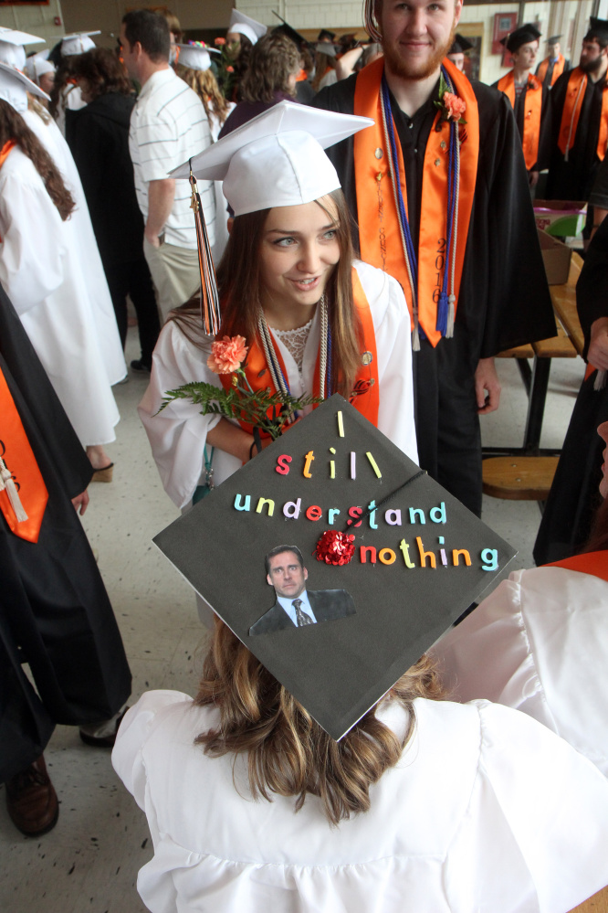 Julia Meade, top, chats with Kaetlyn Stinson prior to the start of commencement ceremonies at Skowhegan Area High School on Sunday. Stinson said her love for "The Office" inspired her to decorate her mortar board with a photo and quote by Michael Scott, played by Steve Carell.