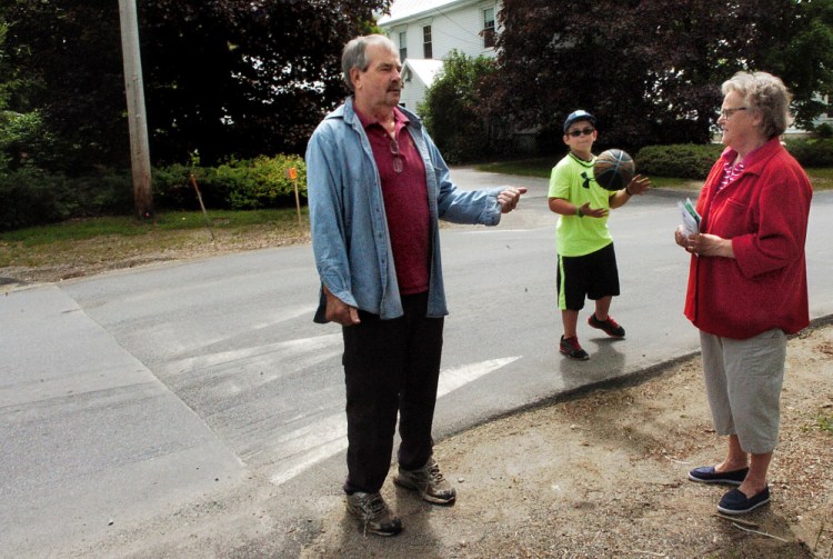 Norridgewock Upper Main Street residents Butch and Cheri White and their grandson Parker, standing near the speed hump on Monday, say they support the raised pavement beside their home and that it slows down drivers in the neighborhood.