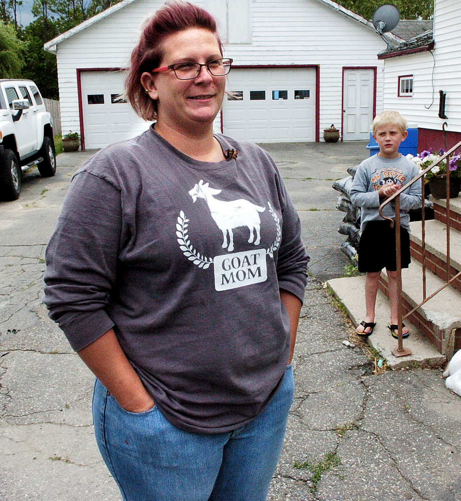 Emily Smith speaks in favor of the speed hump that slows traffic near her home on Upper Main Street in Norridgewock on Monday. In background is her son Slater, who along with his brothers, is not allowed close to the street.