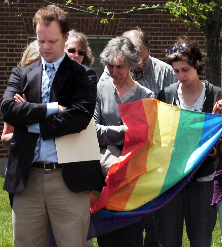 Those attending a vigil Wednesday at Colby College's Miller Library in Waterville in commemoration of the victims of Sunday's Orlando shooting observe a moment of silence. Colby professor Kurt Nelson, left, led the vigil, at which those attending prayed and spoke in support of the victims, the gay community and stronger gun laws and a student read aloud the names of those who were killed.