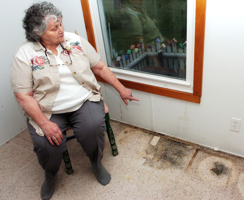 Jan Martin points to where water has seeped inside from a window and contributed to black mold on the carpet in May in a room of her home in Skowhegan. After a Morning Sentinel column publicized the issue and Martin's difficulty getting help, she has received and outpouring of support.