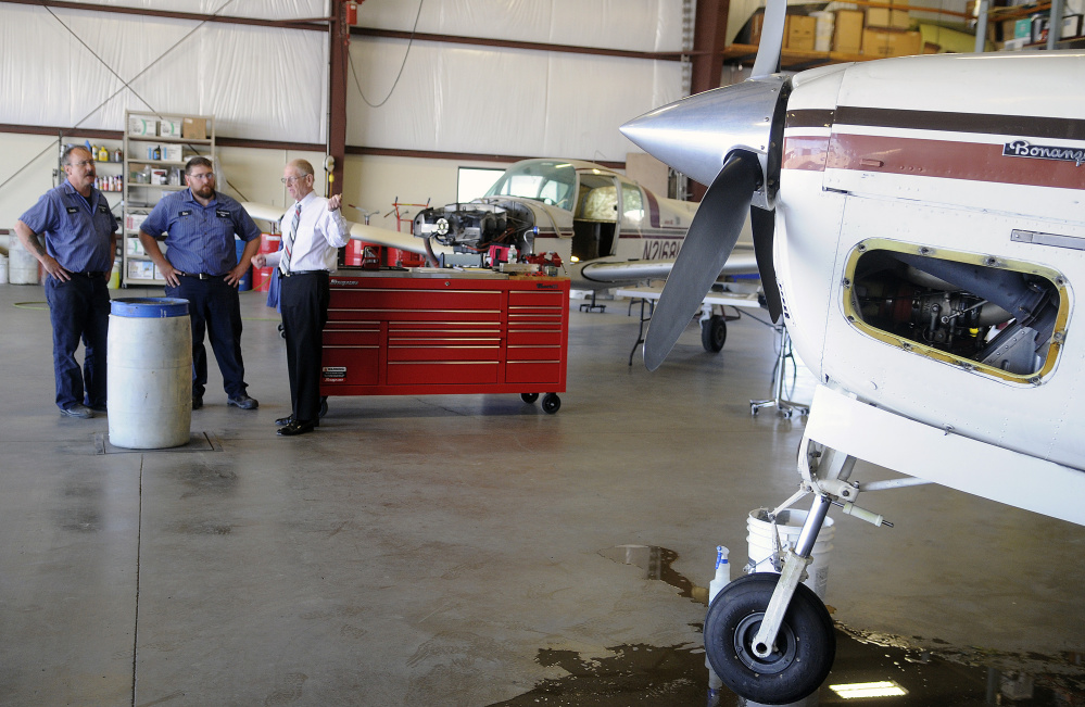 William H. Perry, a proprietor of Maine Instrument Flight, right, speaks with mechanics Kevin Kimball, left, and Samuel Staples on Thursday in the newly renovated mechanical hangar at the firm's headquarters in Augusta. Maine Instrument Flight celebrates 70 years in business on Saturday with special events and low-cost plane rides from the company's newly refurbished corporate hangar at the Augusta State Airport.