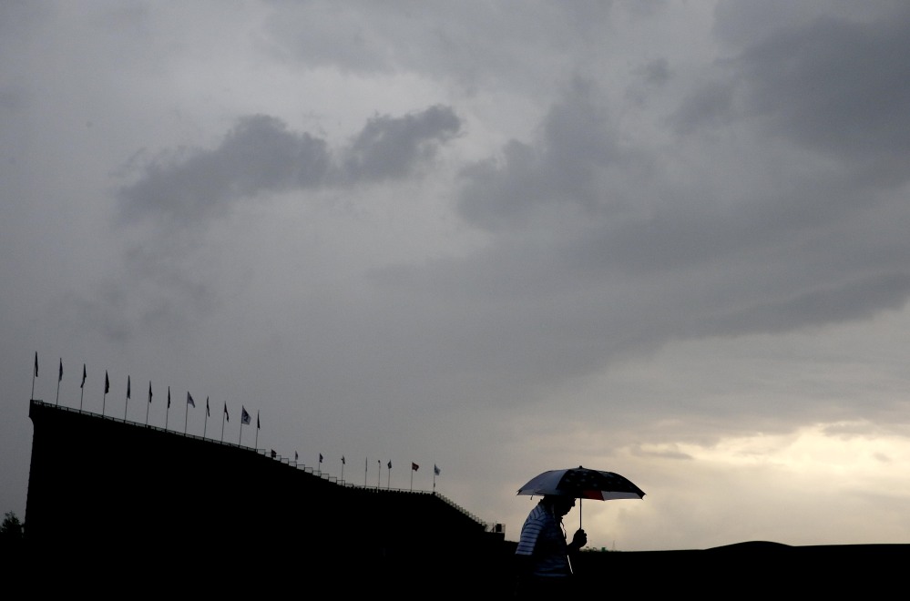 A fan leaves the  Oakmont Country Club course during the third rain delay in the first round of the U.S. Open on Thursday in Oakmont, Pennsylvania.