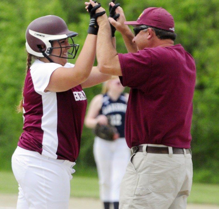 Richmond's Emily Douin, left, celebrates with coach Tony Martin after hitting a two-run triple in the third inning of a Class D South semifinal Friday against Greenville in Richmond.