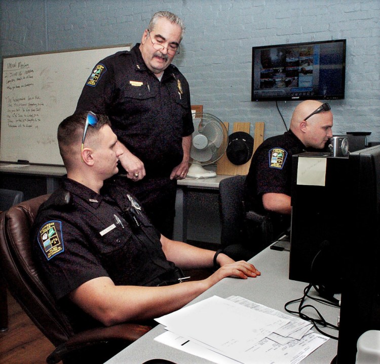 Skowhegan police Chief Don Bolduc, center, oversees officers C.J. Vera, left, and Ian Shalit Wednesday as they fill out police reports at the police station. The department is up to its full complement of 15 officers for the first time in more than a decade.