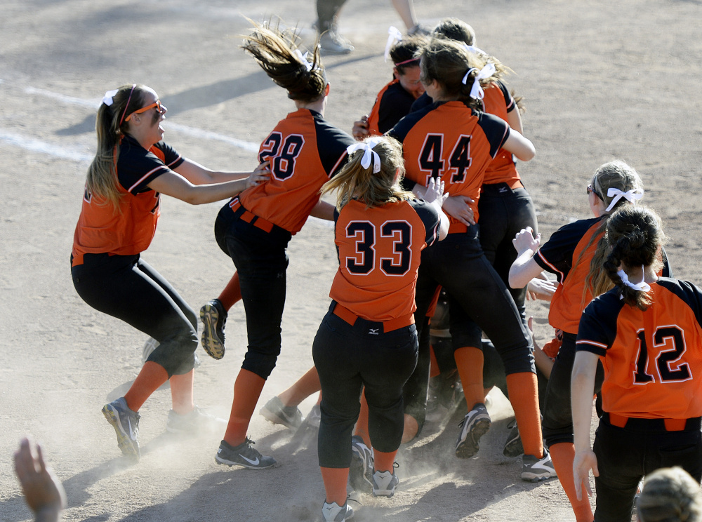 Members of the Biddeford softball team celebrate after defeating Skowhegan 12-7 in the Class A state championship game Saturday in Standish.