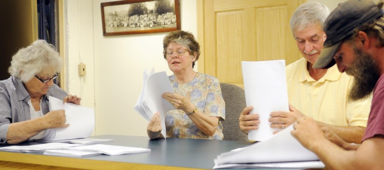 Esther Slattery, left, Rayna Leibowitz, Kenneth Lizotte and Larry Nadeau II inspect ballots Monday at the town office in Litchfield. Political newcomer Tim LaChapelle defeated longtime selectwoman Leibowitz by 12 votes.