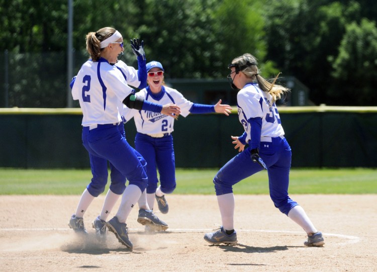 Madison players Kayla Bess, left, Ashley Emery and Madeline Wood converge in the circle after the Bulldogs edged Bucksport 3-1 in the Class C state championship game Saturday at St. Joseph's College in Standish.