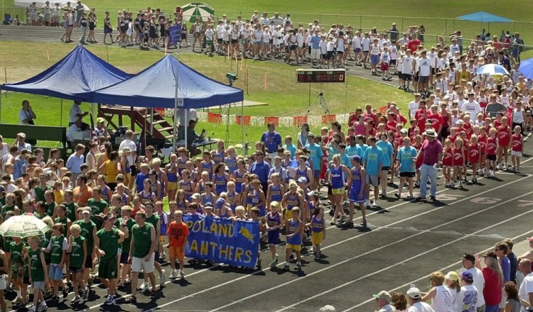 Athletes parade around the Cony High School track during ceremonies at the USA Track and Field State Championships held at Alumni Field in Augusta. Student-athletes, parents and officials propose to rename the track in honor of late track coach Taylor Harmon, who died last October.