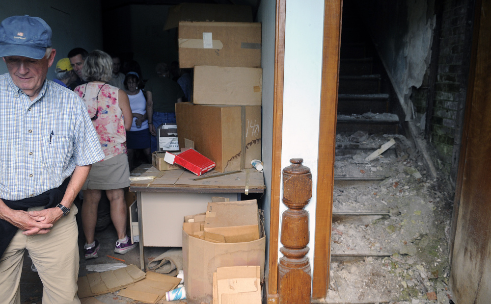 Ken Young, left, walks out of a building at the Stevens School Complex in Hallowell Monday during a tour with the facility's new owner, Matt Morrill. Morrill recently purchased the dilapidated former correctional facility and state office complex.