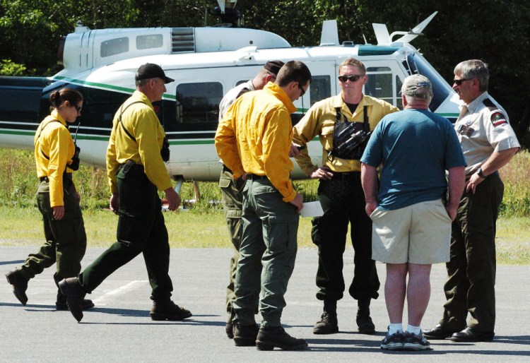Maine Forest Service personnel consult on Monday at the Kingfield Fire Department on status of the fire at the summit of nearby Mount Abram with incident commander Maine Forest Ranger Shane Nichols, third from right, and Chief Ranger William Hamilton.