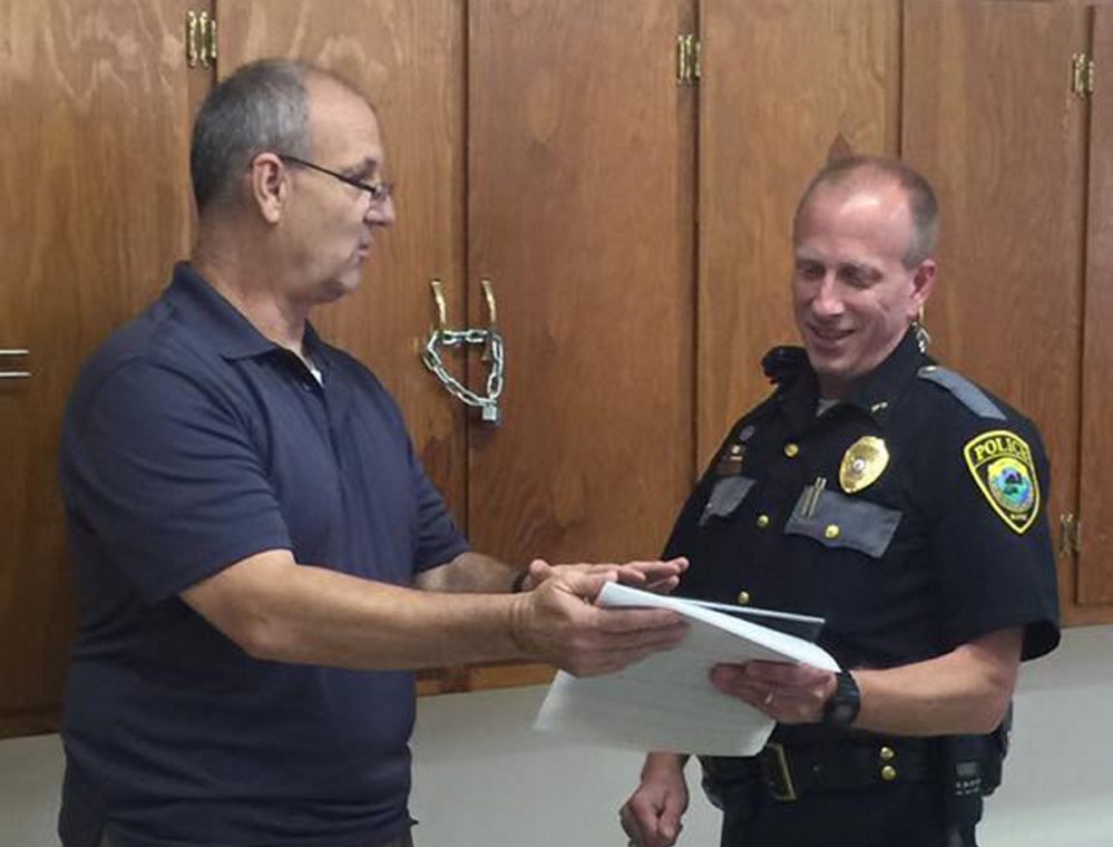 Clinton police Sgt. Stanley Bell, left, commends retiring Chief Craig Johnson last week at a retirement ceremony for Johnson. Bell will become the part-time chief Friday.