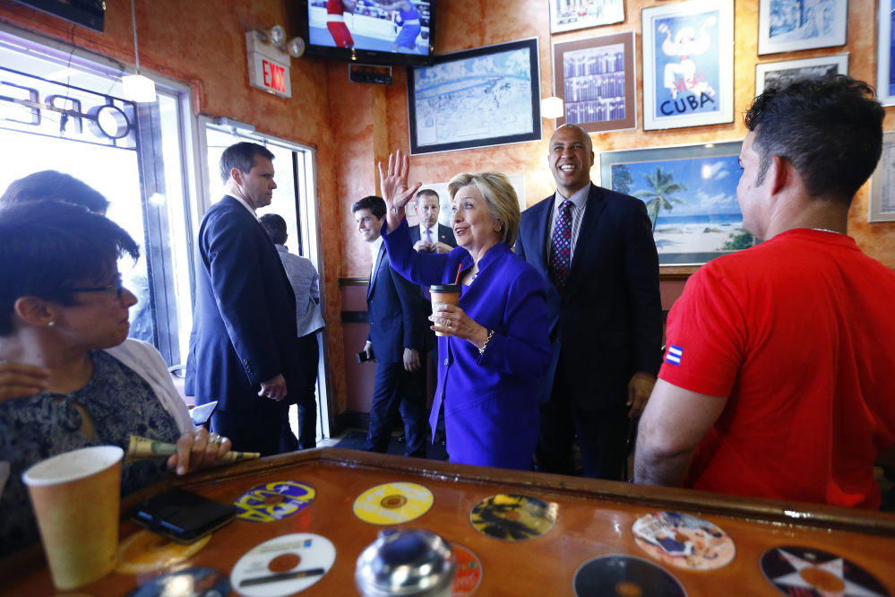 Democratic presidential candidate Hillary Clinton and Sen. Cory Booker, D-N.J., center right, make a stop at Omar's Cafe while campaigning Wednesday in Newark, N.J.
