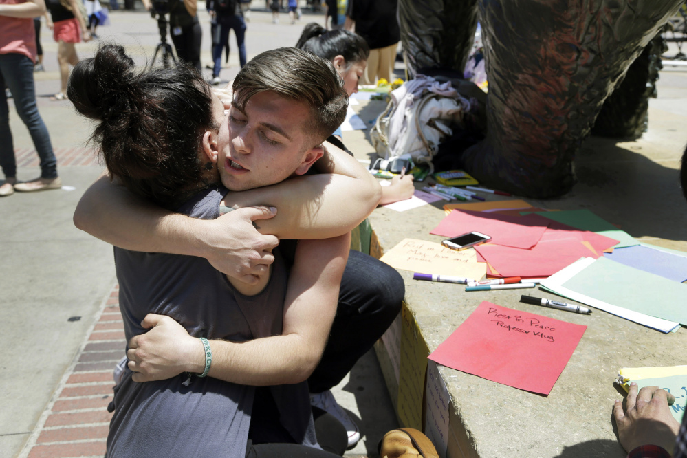 UCLA students Joseph Perez and Stephany Drotman hug after leaving condolence notes at the foot of UCLA's Bruin Bear statue on Thursday. Students wrapped up classwork and prepared for finals as the UCLA campus tried to regain a sense of normalcy a day after being rocked by a murder-suicide that prompted a lockdown and an enormous police response.