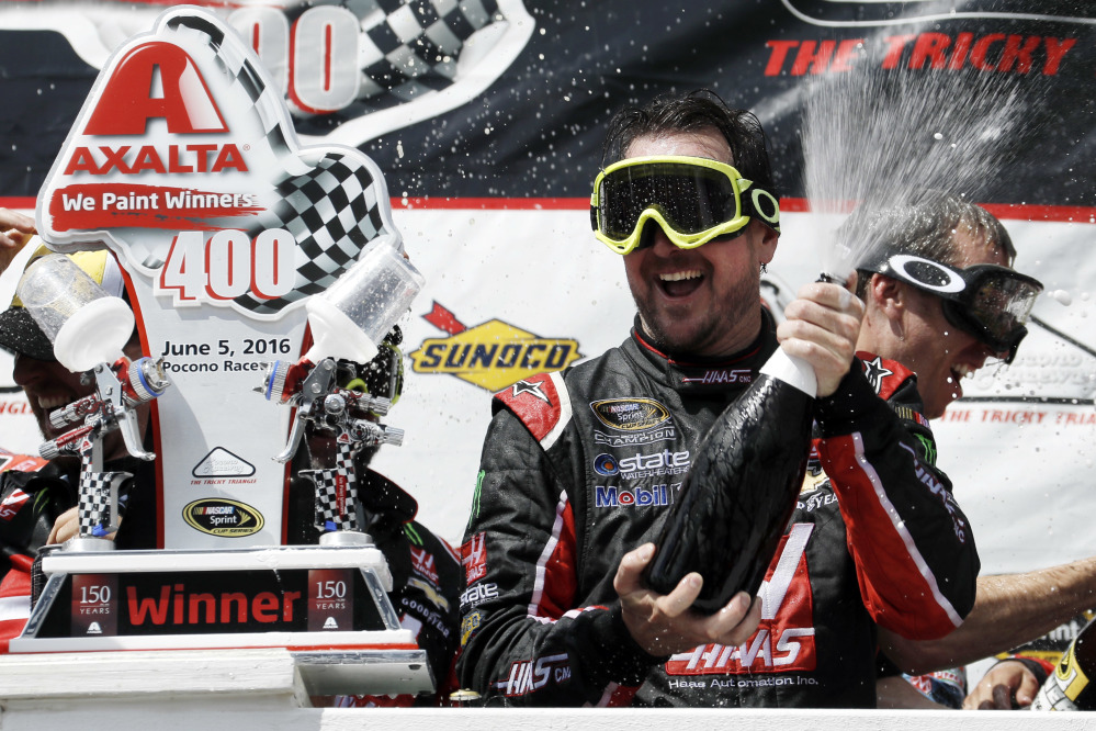 Kurt Busch celebrates with his team in victory lane after winning the NASCAR Sprint Cup race Monday at Pocono Raceway in Long Pond, Pennsylvania.