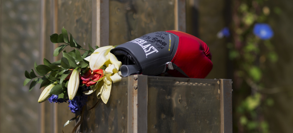 Flowers and a boxing glove are left at a makeshift memorial to Muhammad Ali at the Muhammad Ali Center. Ali's memorial service will feature former President Bill Clinton.