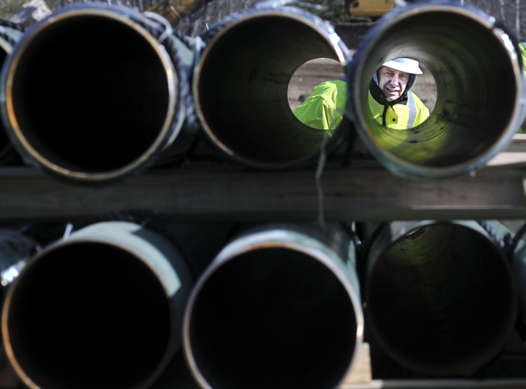 A worker inspects natural gas pipeline to be installed in the Kennebec County town of Windsor. Gas prices soared in the frigid winter of 2012-13, leading to calls for pipeline expansion.