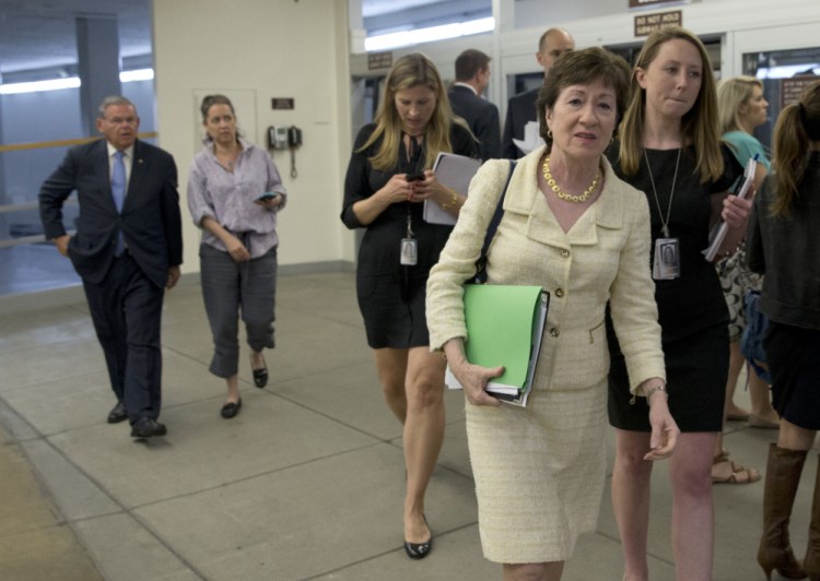 Sen. Susan Collins, R-Maine, second from right, walks towards the Senate on Capitol Hill Monday in Washington.