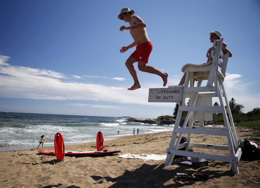 Lifeguards Nate Samson, 18, of Brunswick, Maine, left, and Kyle Hummel, 19, of Bath, Maine, patrol a section of Mile Beach on Thursday at Reid State Park in Georgetown. States where lifeguarding is seasonal have a harder time keeping positions filled.