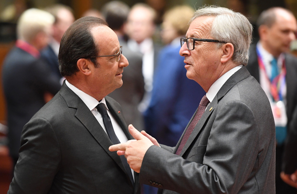 European Commission President Jean-Claude Juncker, right, speaks with French President Francois Hollande during a round table meeting at an EU summit in Brussels on Tuesday.
