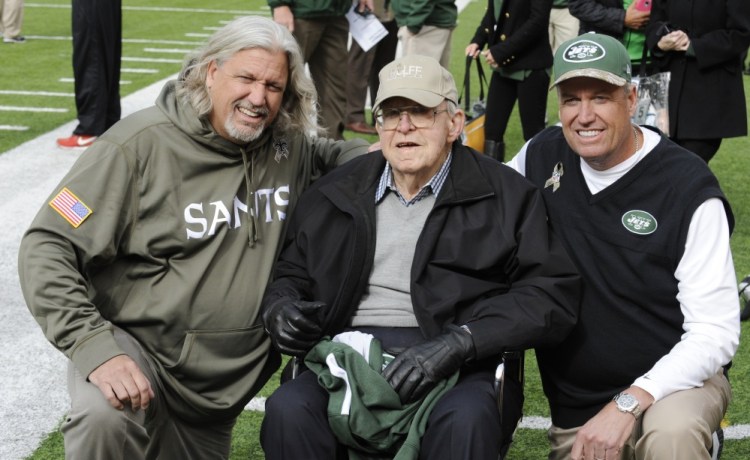 Then-New Orleans Saints defensive coordinator Rob Ryan, left, poses for a 2013 photographs with his father Buddy Ryan, center, and brother, then-New York Jets head coach Rex Ryan, right, before an NFL football game in East Rutherford, N.J. Buddy Ryan, who coached two defenses that won Super Bowl titles and whose twin sons Rex and Rob have been successful NFL coaches, died Tuesday. He was 82.