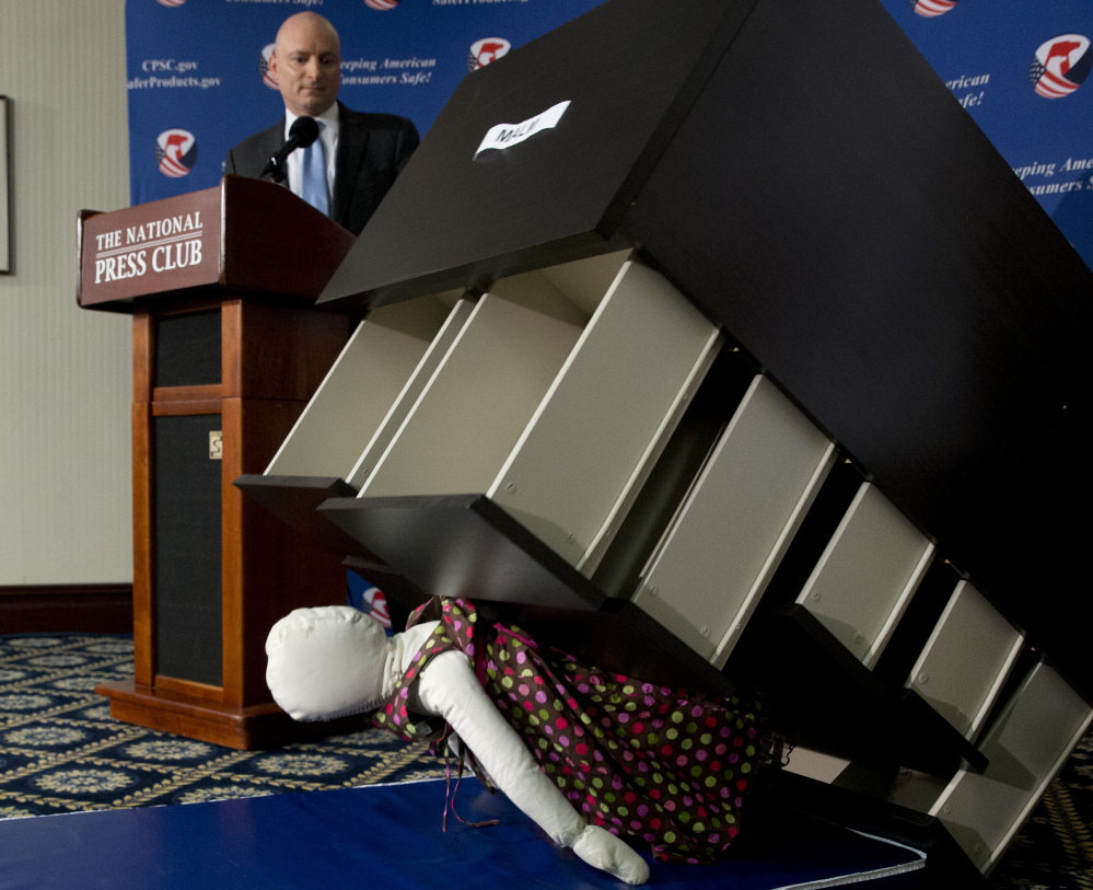 During a news conference in Washington, D.C., on Tuesday, Consumer Product Safety Commission Chairman Elliot Kaye watches how an Ikea dresser can tip and fall on a child.