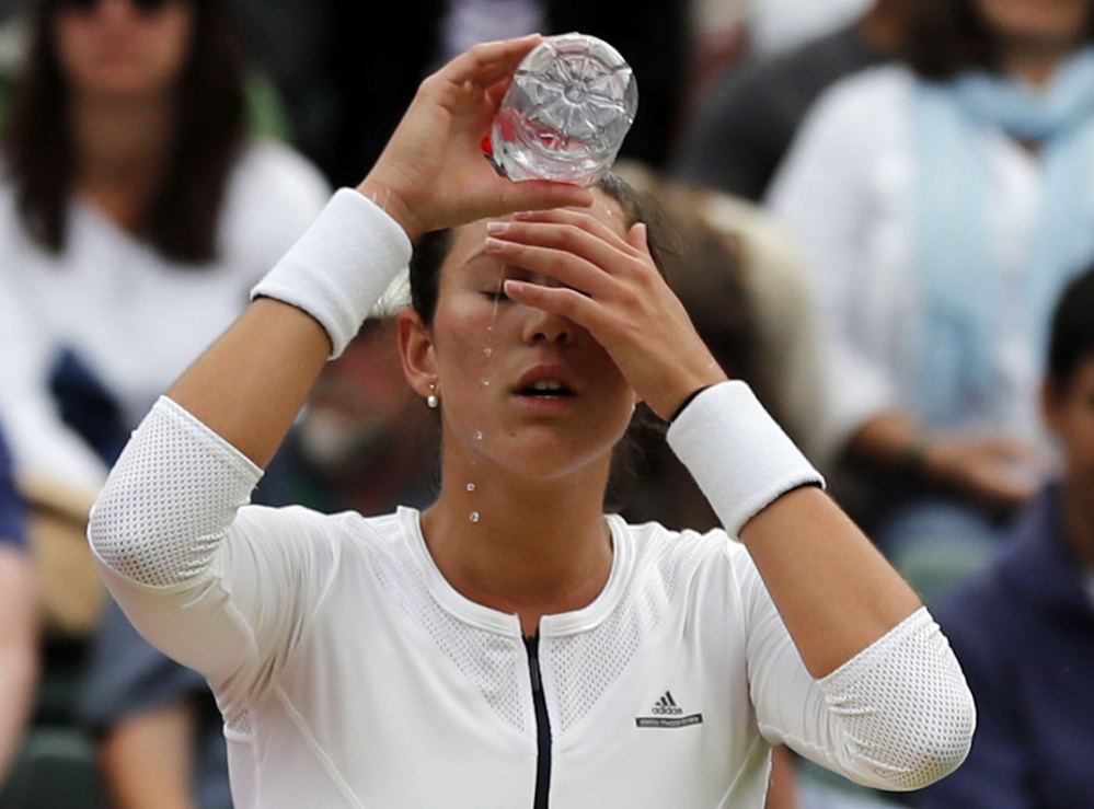 Garbine Muguruza of Spain cools down Thursday during a break in her Wimbledon singles match against Jana Cepelova of Slovakia. A total of 18 seeded players, including Muguruza, lost on Day 4 of the tournament.