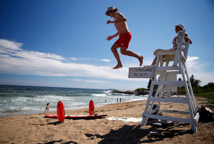 Lifeguards Nate Samson, 18, of Brunswick, left, and Kyle Hummel, 19, of Bath, patrol a section of Mile Beach at Reid State Park on Thursday in Georgetown.