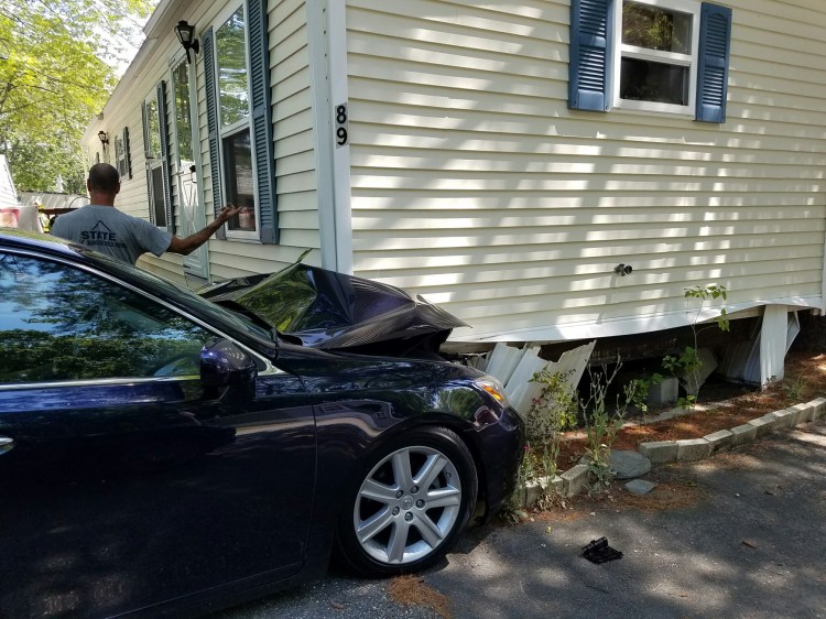 A car is wedged under a trailer home in Scarborough on Monday. (Courtesy Scarborough Fire Department)