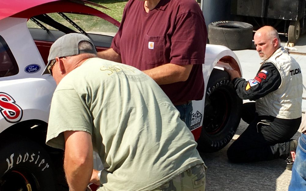 Five-time Wiscasset Speedway Pro Stock champion Scott Chubbuck and his crew work on his car after a practice run on on Saturday.