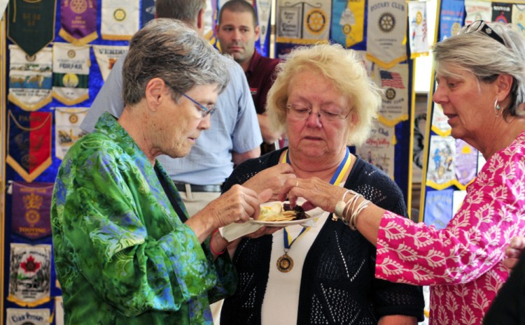 City councilor Dale McCormick, left, chats with Arlene Gagnon and Cheryl Clukey on Friday during the Augusta Rotary Centenary celebration at the Cohen Center in Hallowell.