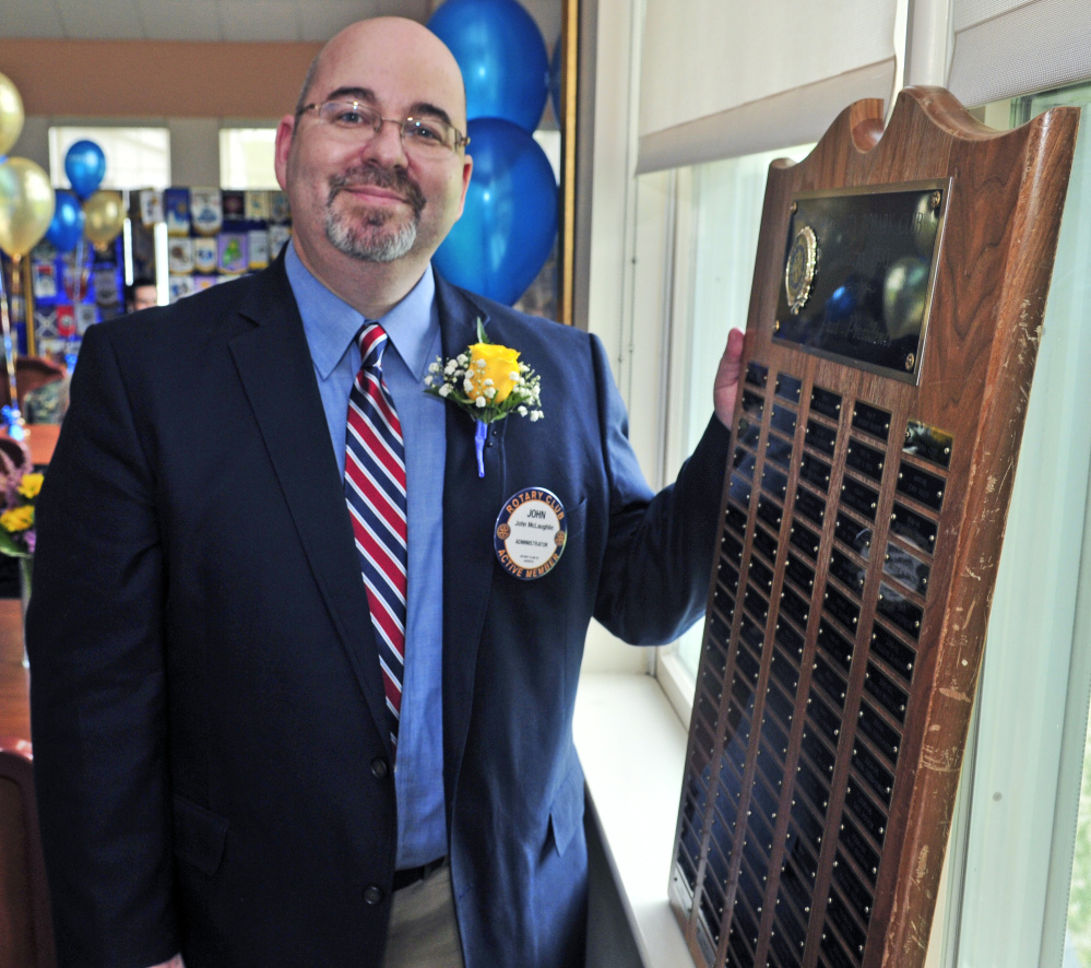 President John McLaughlin stands with a plaque listing the previous holders of his office over the last century on Friday during the Augusta Rotary Centenary celebration at the Cohen Center in Hallowell.