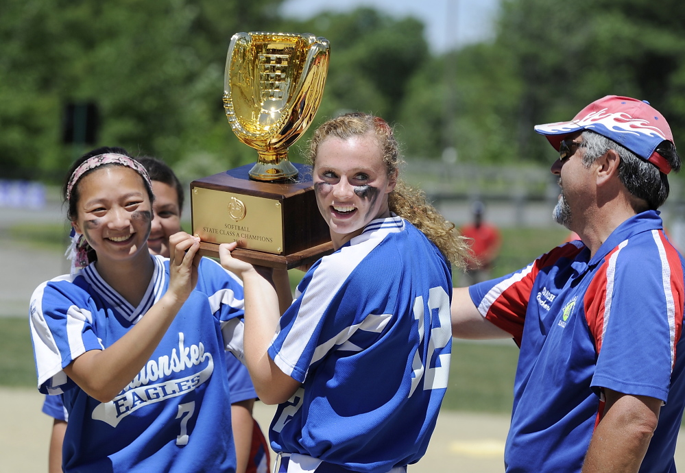 Messalonskee softball coach Leo Bouchard, right, watches Mollyan Killingbeck, left, and Kristy Prelgovisk hold up the Class A state championship trophy after the Eagles edged Scarborough 1-0 in the 2015 Class A state title game. Bouchard recently resigned, citing the physical demands of the job.