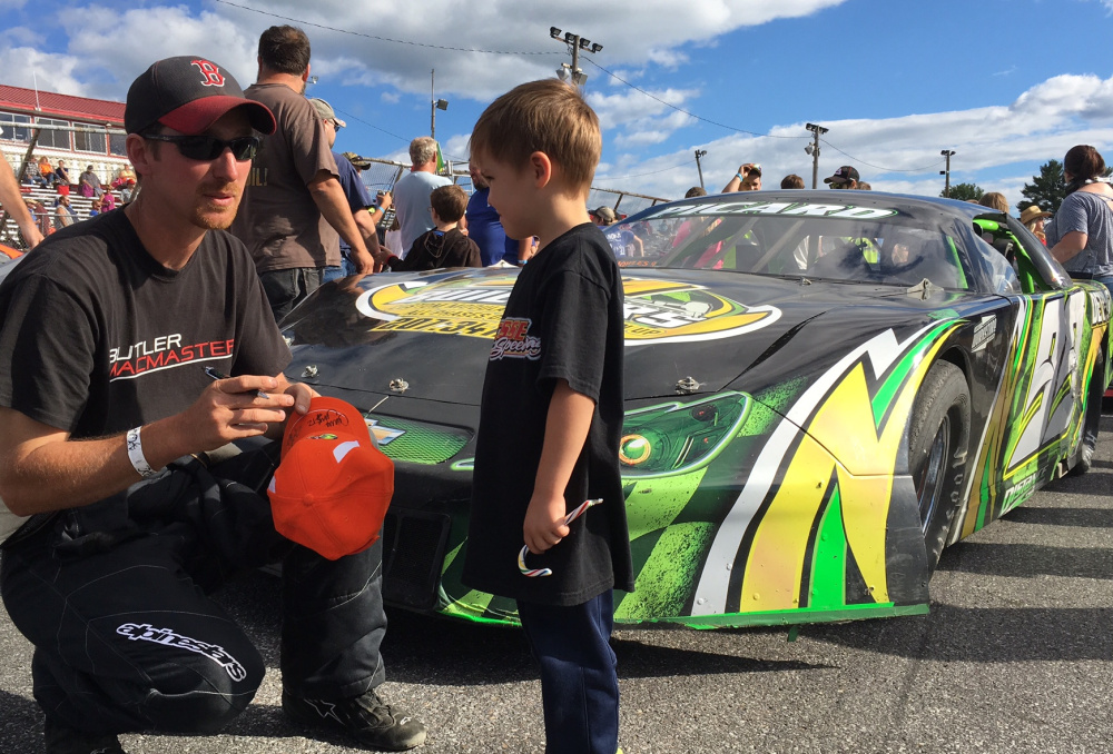Ajay Picard, of Palmyra, signs an autograph for a young fan at Wiscasset Speedway on Saturday. Picard sits second in the track's Pro Stock standings and is closing in on his first win.