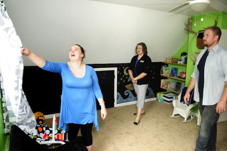Abby Utecht, left, and Steve Utecht show Sarah Graettinger, a staffer from U.S. Sen. Angus King's office, the nursery of their new home after a news conference Friday in Richmond.