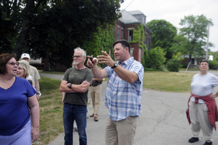 Matt Morrill, center, describes a public road he wants to build for a housing development at the Stevens School complex in Hallowell during a recent tour of the property.
