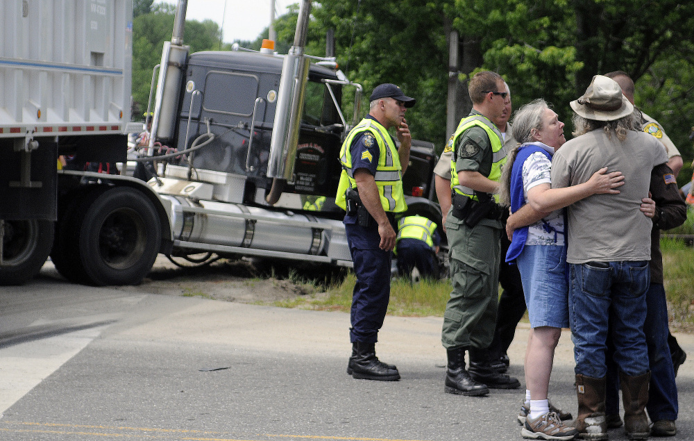 Friends and family of people injured in a collision Tuesday console each other on Route 126 in Litchfield. One person in a passenger car that collided with a tractor-trailer died at the scene while two others were taken to area hospitals.