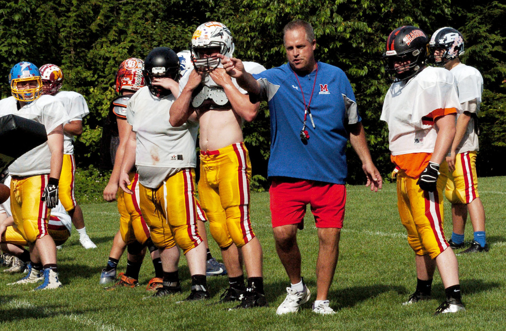 Messalonskee football coach Brad Bishop, center, instructs members of the East team during a Maine Shrine Lobster Bowl practice Tuesday at Dover-Foxcroft.