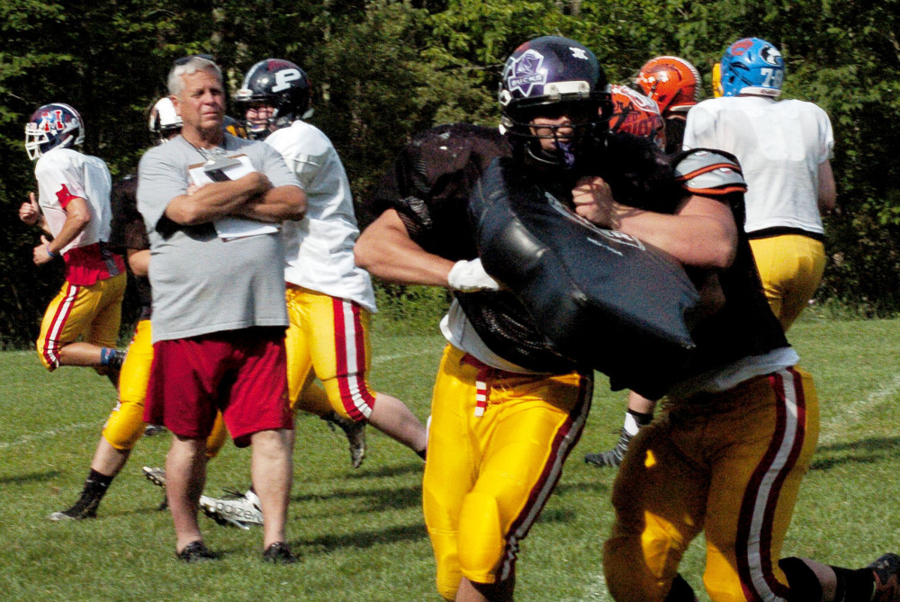 East team coach Mike Marston watches players, including Winslow's Alec Clark, during Maine Shrine Lobster Bowl practice Tuesday during training camp at Dover-Foxcroft.