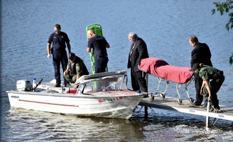 Funeral home workers from Smart and Edwards in Skowhegan arrive June 30 at the Oosoola Park boat landing on the Kennebec River in Norridgewock to transport a drowning victim, Barbara York, of Waterville.
