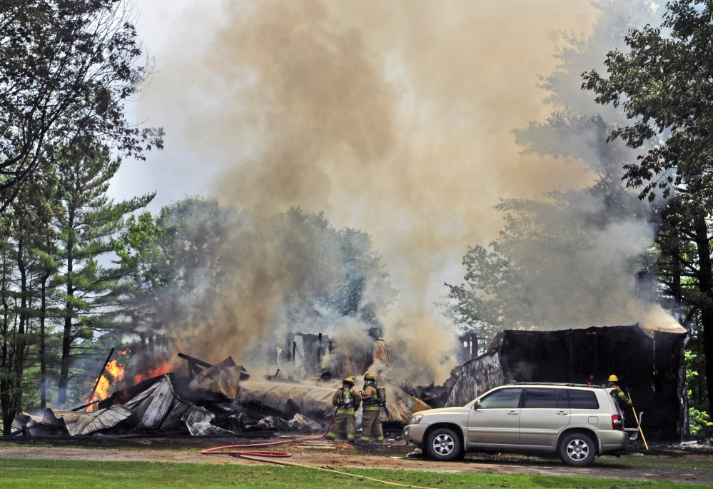 Firefighters battle a blaze Sunday at 35 Holway Road in Sidney.