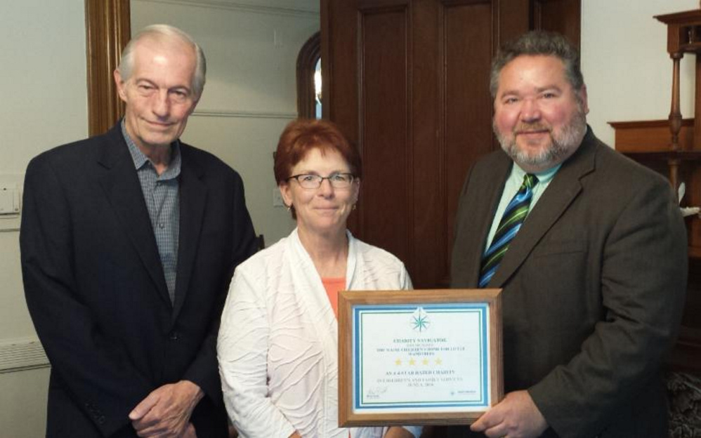 The Maine Children's Home for Little Wanderers' Stephen Mayberry, development director, left; Diana Rafuse, finance director, center; and Rick Dorian, executive director, right, with The Maine Children's Home's Charity Navigator 4-star certificate.
