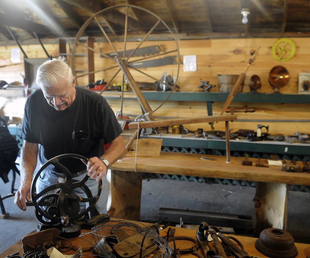 Dick Harriman sets up items for display Tuesday in the museum at the Pittston Fair.