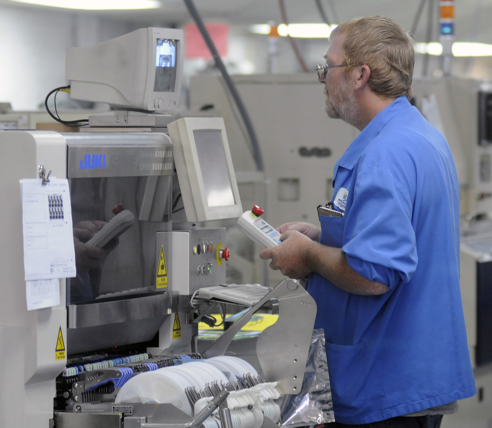 Ron Crocker works on a machine at Alternative Manufacturing Inc. in Winthrop Wednesday.