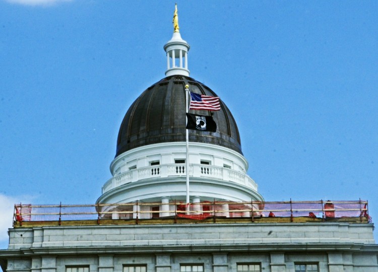 A fence rings the roof of the Senate wing of the State House on Tuesday in Augusta, where a crew is replacing decorative ledges and fixing the roof.