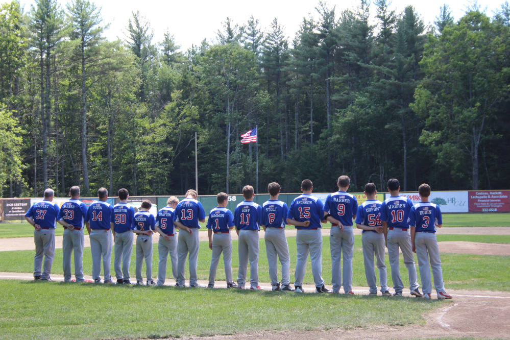 Members of the Augusta 13 Babe Ruth team stand at attention prior to its New England regional game against Taunton, Massachusetts, on Tuesday.