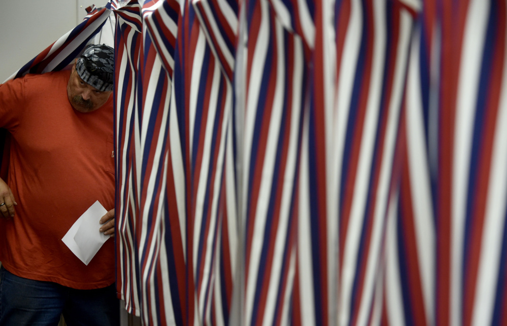 Eric Webster, of New Sharon, leaves the voting booth Thursday after casting a ballot on the Regional School Unit 9 school budget at the New Sharon Town Office.