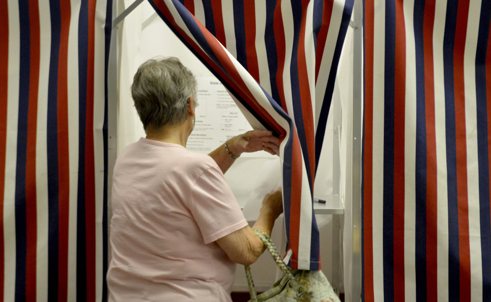 Mary Harris, of New Sharon, enters a voting booth Thursday to cast a ballot on the Regional School Unit 9 school budget at the New Sharon Town Office.