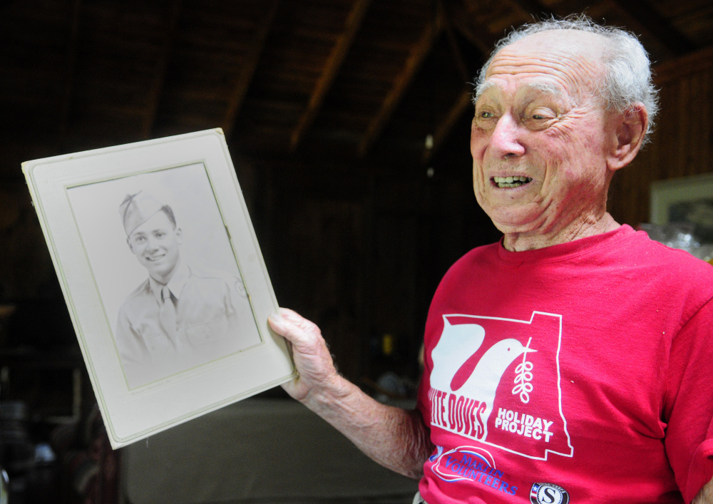 Holding a picture of himself after being discharged from U.S. Army, Alfred Jacobs, 92, talks about serving in World War II on Tuesday during an interview at his summer home in Readfield.
