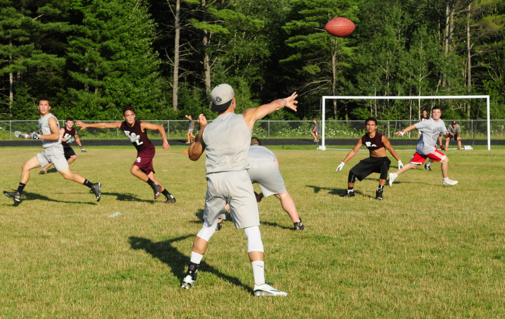Winthrop/Monmouth slot back Nate Scott, center, throws a pass to Kane Gould during a 7-on-7 game against Edward Little on Friday in Turner.